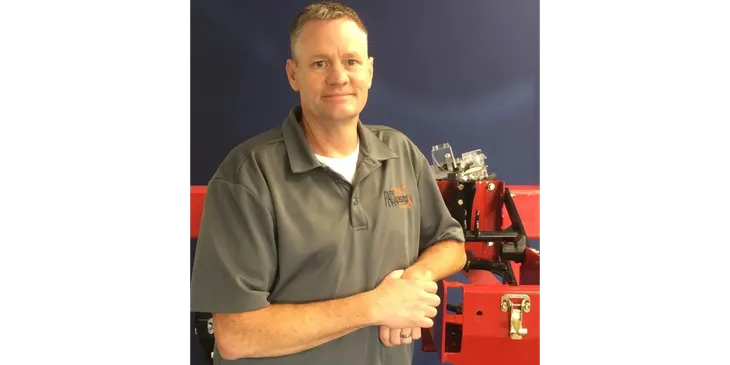 Person in gray shirt beside machinery