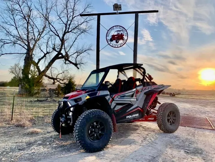 Polaris ATV under a rustic sign